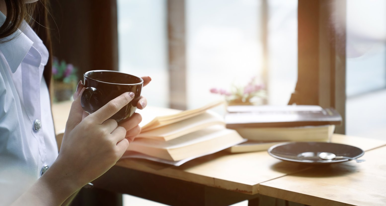 Crop businesswoman drinking coffee in cafe